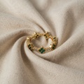 Anni – Goldring mit Blumenverzierungen und Smaragd-Element.