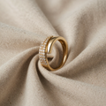 Goldfarbener Ring mit funkelndem Steinbesatz und Wickeloptik