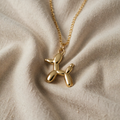 Goldene Halskette mit einem Anhänger in Form eines Luftballonhundes mit künstlerischem Design