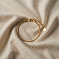 Goldfarbenes Schlangenarmband mit rundem Anhänger