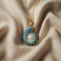 Halskette mit blau-goldener Schneckenmuschel und Perlenoptik